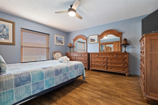 bedroom featuring ceiling fan, dark hardwood / wood-style flooring, and a textured ceiling