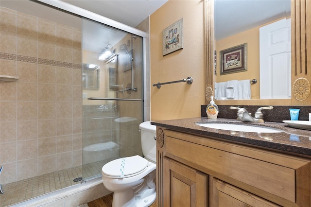 bathroom with walk in shower, vanity, and toilet