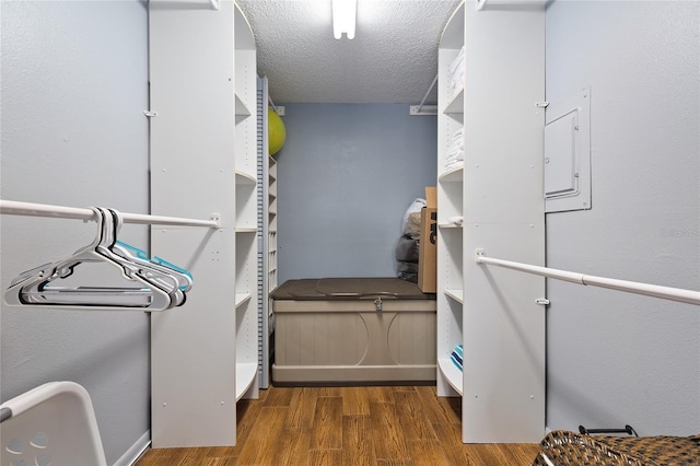 clothes washing area with a textured ceiling and dark wood-type flooring