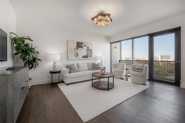 living room with dark wood-type flooring and a notable chandelier