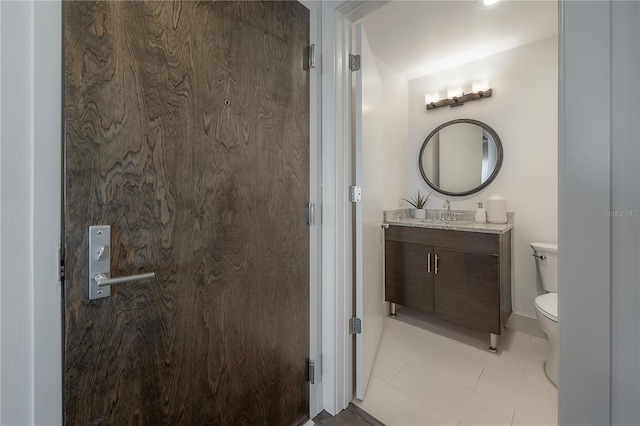 bathroom featuring tile patterned floors, vanity, and toilet