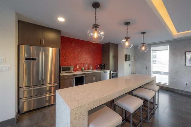 kitchen with a kitchen bar, sink, wine cooler, light stone counters, and stainless steel appliances