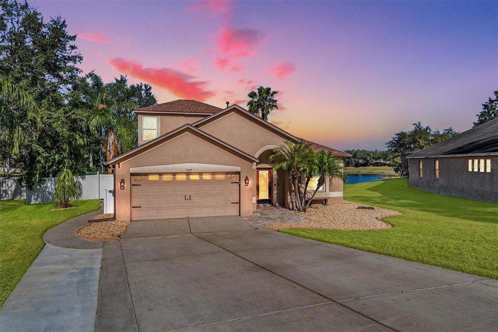 view of front of property with a yard and a garage