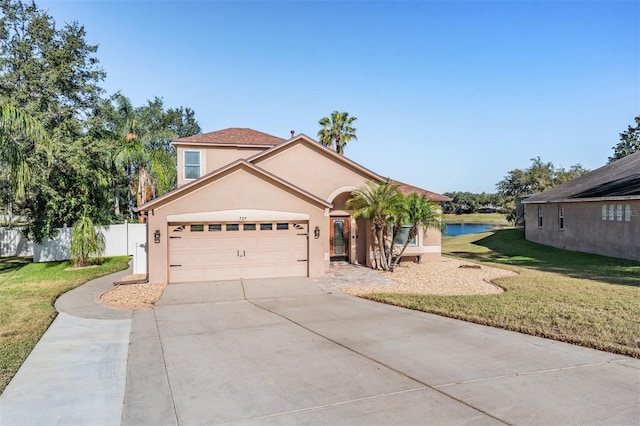 view of front of property with a garage, a water view, and a front lawn