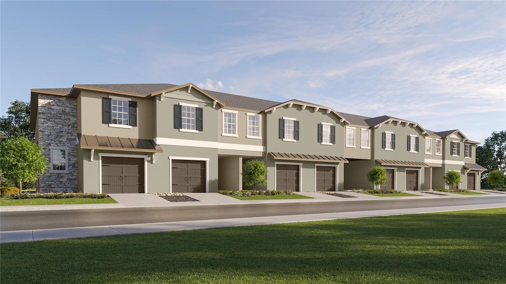 view of property featuring a garage and a front lawn