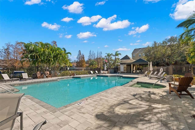 view of swimming pool featuring a community hot tub and a patio area