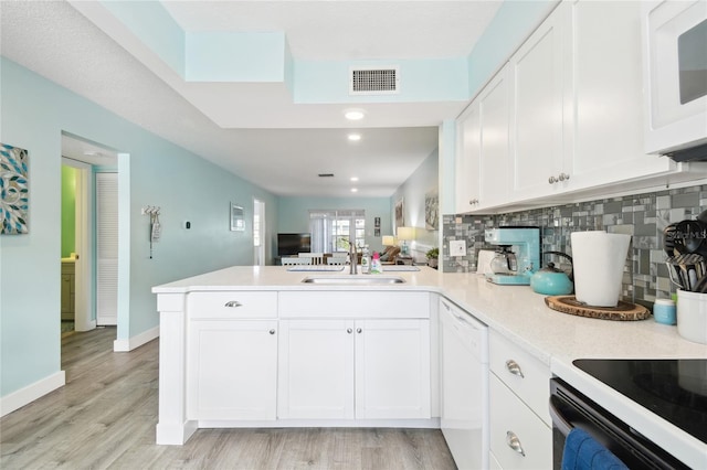 kitchen with sink, kitchen peninsula, light hardwood / wood-style floors, white appliances, and white cabinets