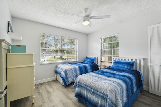 bedroom featuring ceiling fan, a textured ceiling, and hardwood / wood-style flooring