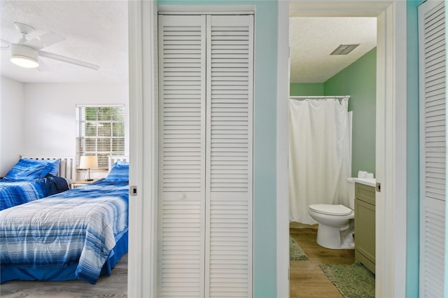 bedroom featuring ceiling fan, light hardwood / wood-style floors, and a textured ceiling