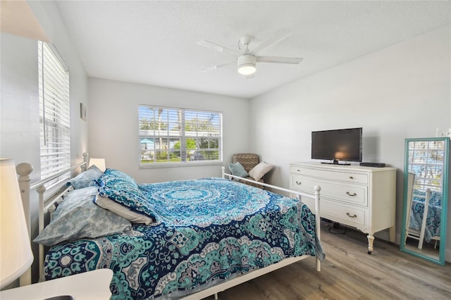 bedroom with ceiling fan, a textured ceiling, and light hardwood / wood-style flooring