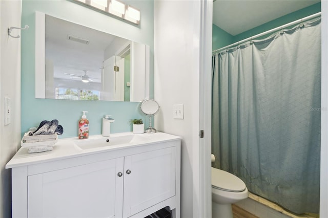 bathroom featuring a shower with shower curtain, vanity, ceiling fan, and toilet