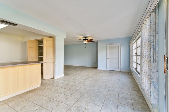 tiled spare room featuring ceiling fan