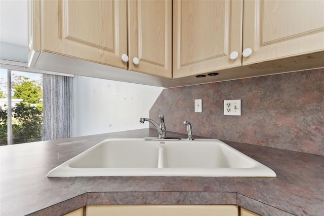 interior details with backsplash, light brown cabinets, and sink