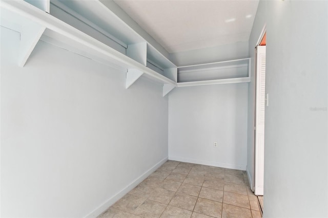 walk in closet with light tile patterned flooring