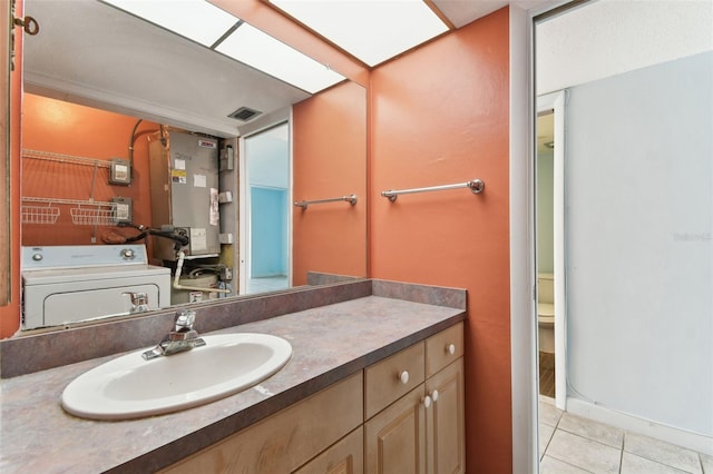 bathroom featuring tile patterned floors, toilet, vanity, and washer / dryer