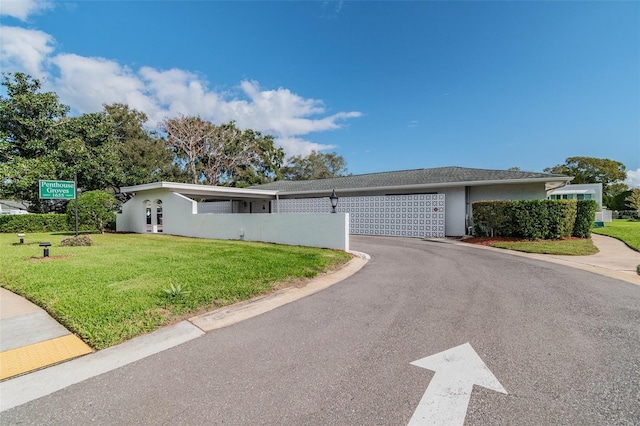 ranch-style home featuring a garage and a front yard