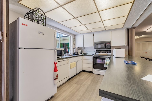 kitchen featuring a paneled ceiling, white appliances, sink, light hardwood / wood-style flooring, and white cabinetry