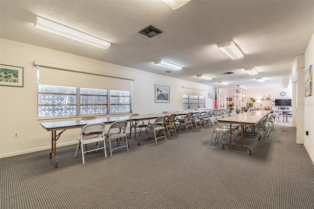 dining area featuring a textured ceiling and dark colored carpet