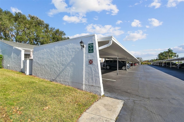 view of parking / parking lot featuring a lawn