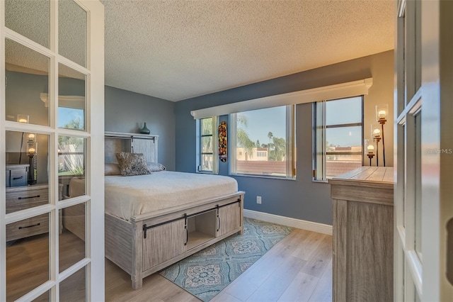 bedroom featuring light hardwood / wood-style floors and a textured ceiling