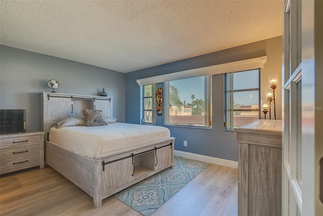 bedroom featuring a textured ceiling and light wood-type flooring