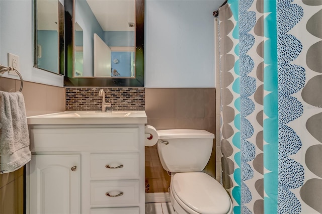 bathroom with decorative backsplash, vanity, tile walls, and toilet