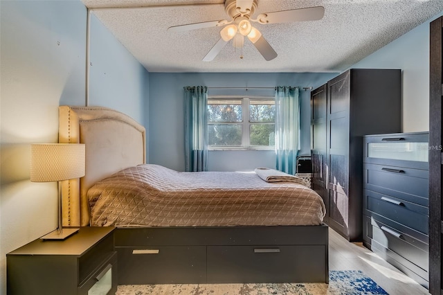 bedroom with ceiling fan and a textured ceiling