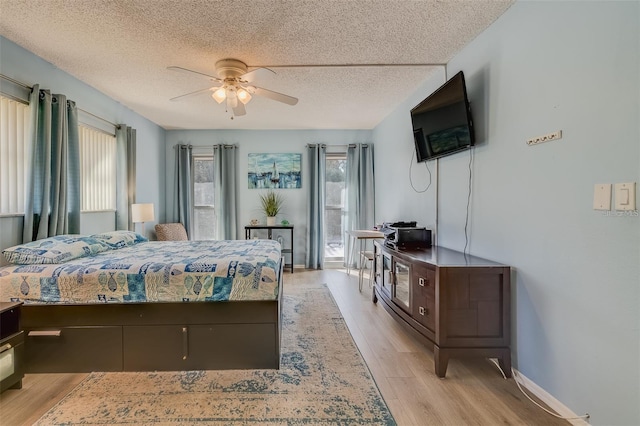 bedroom featuring ceiling fan, light hardwood / wood-style flooring, and a textured ceiling