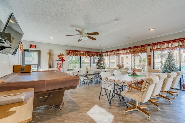 dining space with ceiling fan, light hardwood / wood-style floors, a textured ceiling, and billiards