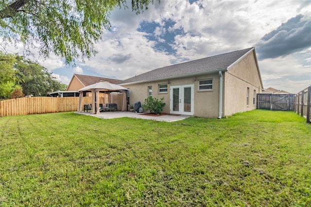 rear view of house with a gazebo, a patio area, a lawn, and french doors