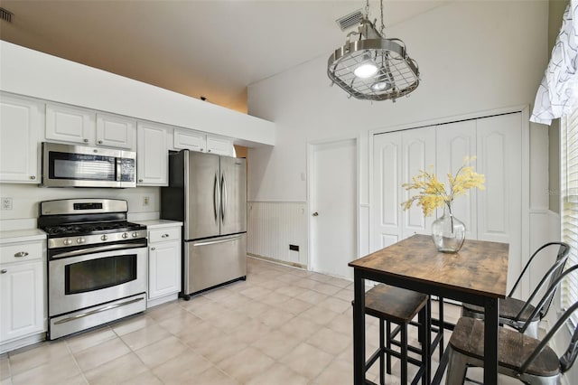 kitchen with white cabinets, light tile patterned floors, and appliances with stainless steel finishes