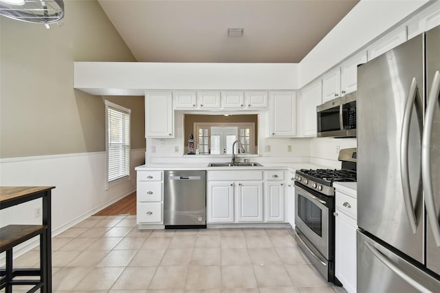 kitchen with sink, white cabinetry, stainless steel appliances, and light tile patterned floors