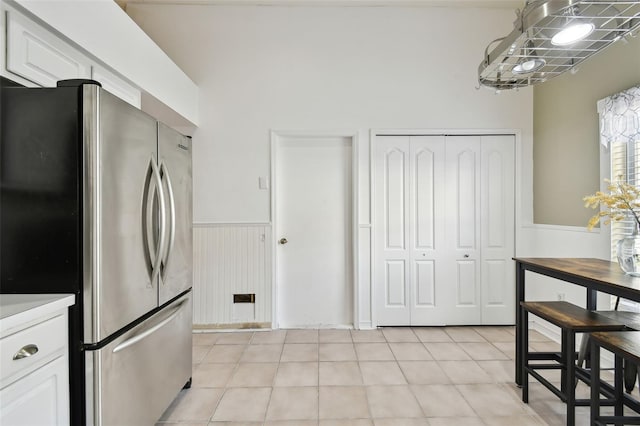 kitchen featuring light tile patterned floors, white cabinetry, and stainless steel refrigerator