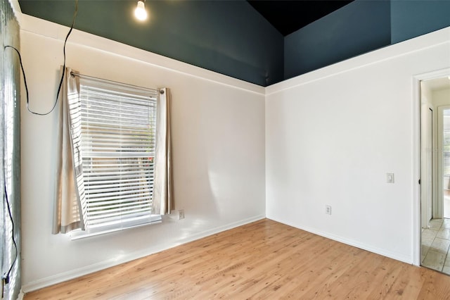 spare room with hardwood / wood-style floors and plenty of natural light