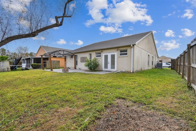 back of property featuring french doors and a lawn