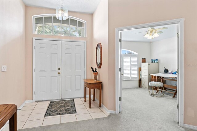 foyer with ceiling fan and light colored carpet