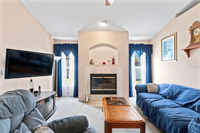 living room featuring a textured ceiling, light carpet, and a tiled fireplace