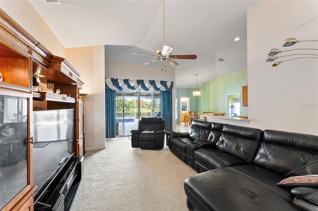 carpeted living room with ceiling fan and high vaulted ceiling