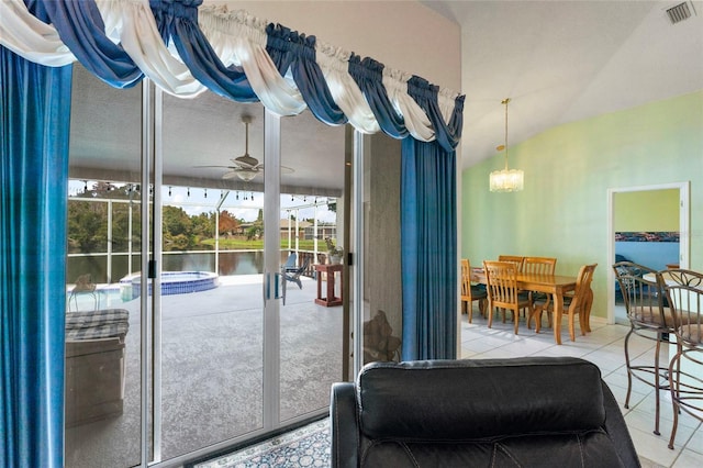 doorway featuring light tile patterned floors, a water view, vaulted ceiling, and ceiling fan