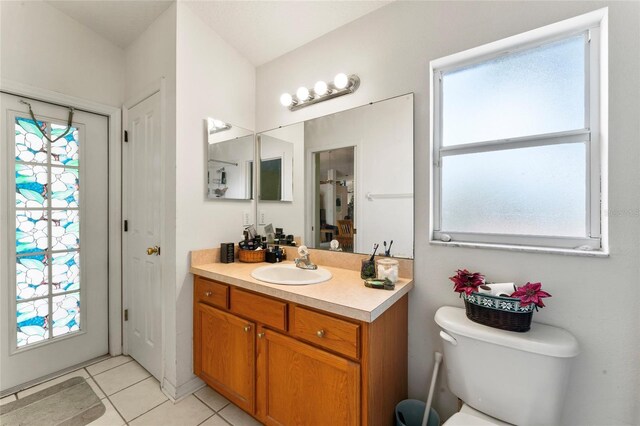 bathroom with tile patterned flooring, vanity, toilet, and plenty of natural light