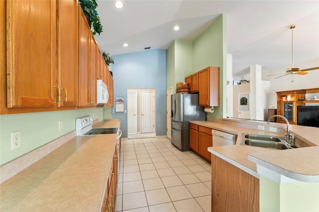 kitchen featuring high vaulted ceiling, sink, ceiling fan, electric range oven, and stainless steel refrigerator