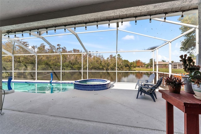 view of pool featuring glass enclosure, an in ground hot tub, a patio area, and a water view