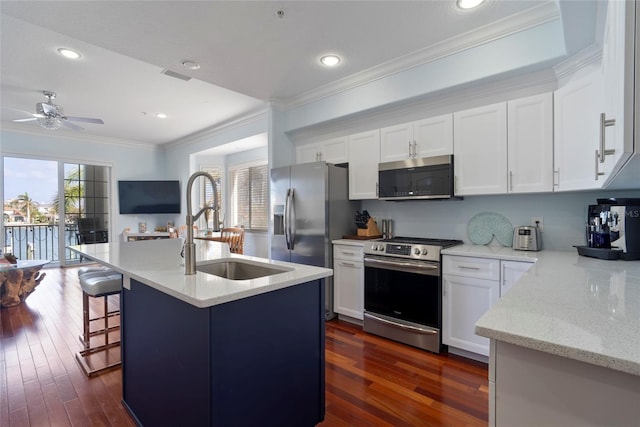 kitchen featuring sink, white cabinets, a kitchen island with sink, stainless steel appliances, and light stone countertops