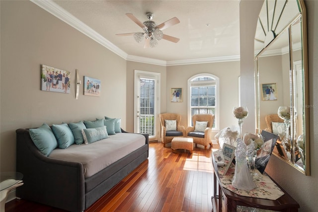 living room with crown molding, ceiling fan, and dark wood-type flooring