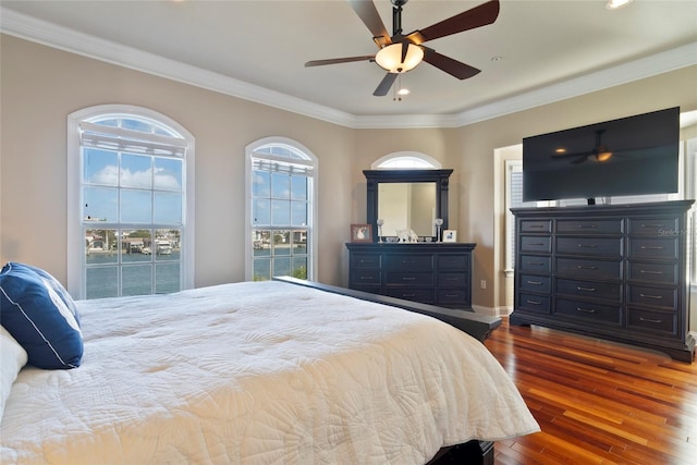 bedroom with multiple windows, hardwood / wood-style floors, ornamental molding, and ceiling fan