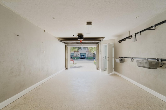 garage with baseboards and a garage door opener