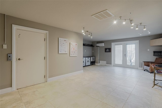 living room featuring baseboards, visible vents, a wall mounted air conditioner, french doors, and track lighting