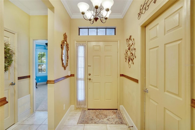 foyer entrance with a notable chandelier, light tile patterned flooring, and ornamental molding