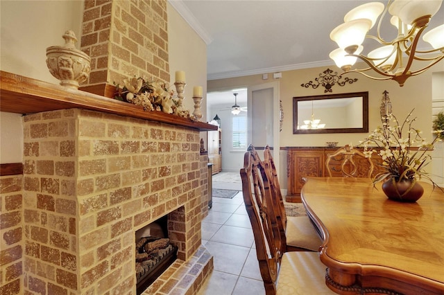 dining room featuring crown molding, light tile patterned floors, ceiling fan with notable chandelier, and a brick fireplace