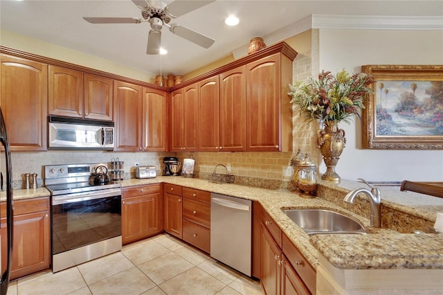 kitchen featuring light stone countertops, appliances with stainless steel finishes, ceiling fan, sink, and light tile patterned flooring